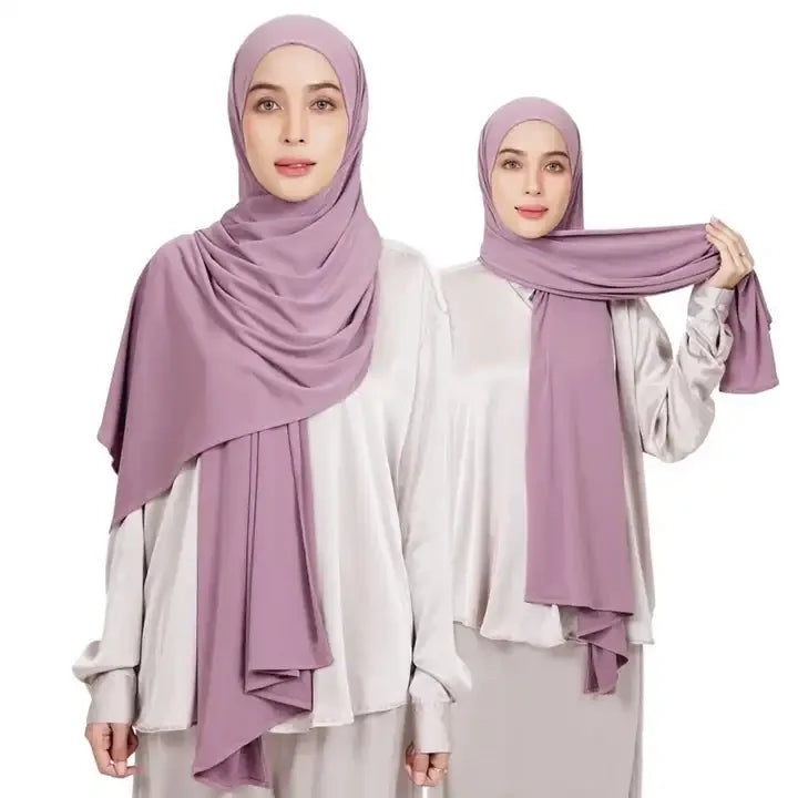 Une femme portant un foulard instant en jersey extensible lilas et une tenue assortie.