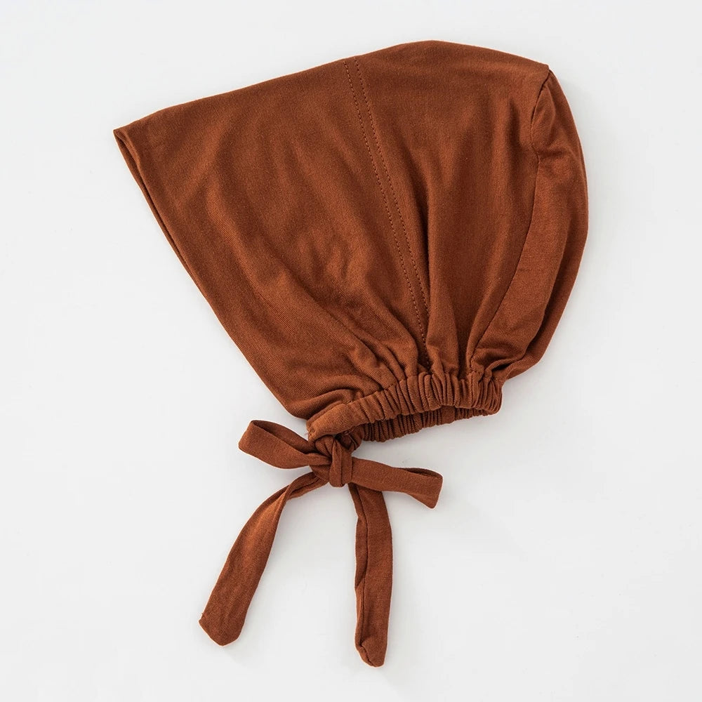 Ein brauner, fester Hijab-Bonnet mit zusammengefaltetem Stoff und einem Schnurzug.