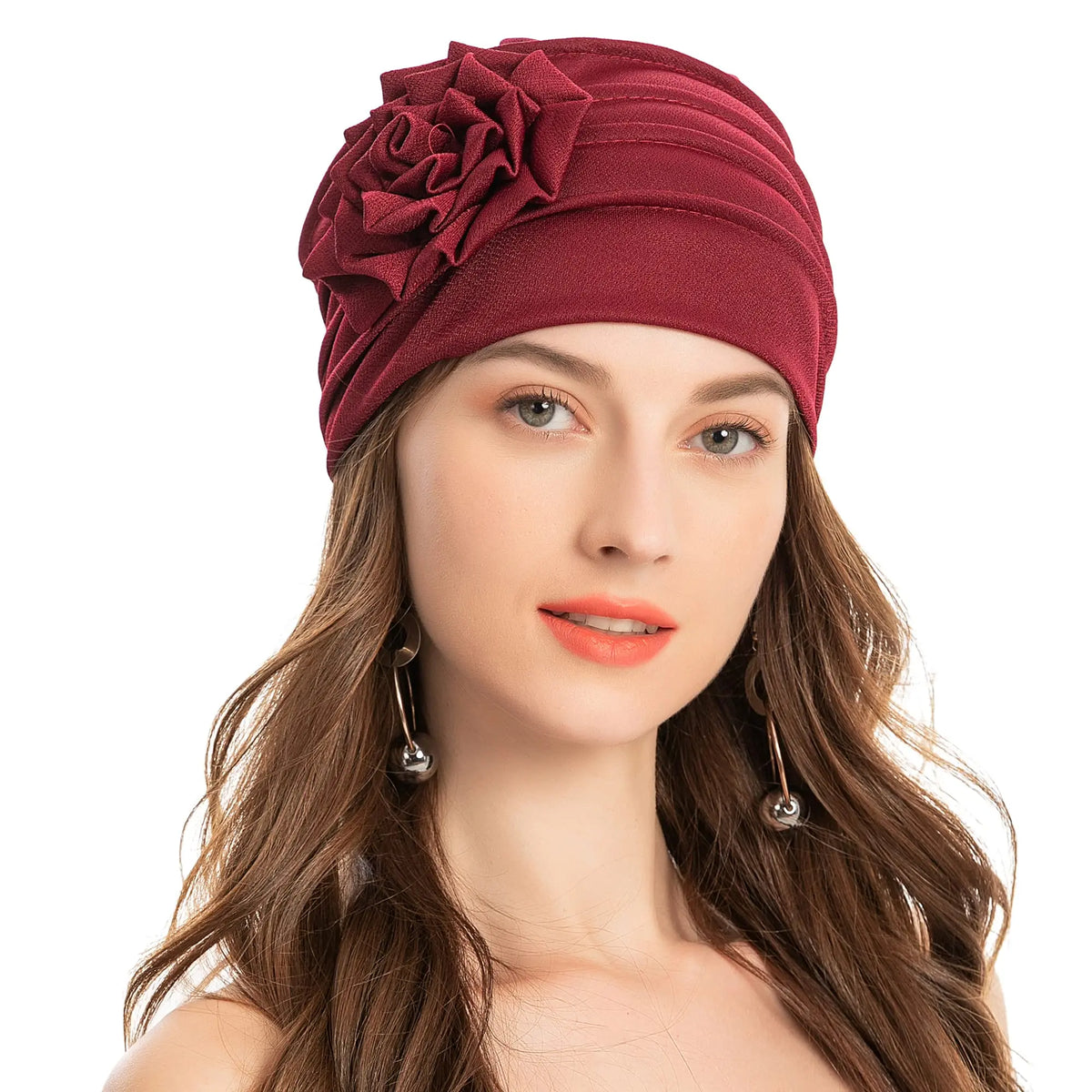 Eine Frau trägt eine tiefburgندية florale bestickte Hijab-Turbanmütze mit langen braunen Haaren.