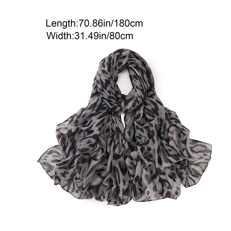 Écharpe pashmina à imprimé léopard gris et noir, drapée pour exposition.