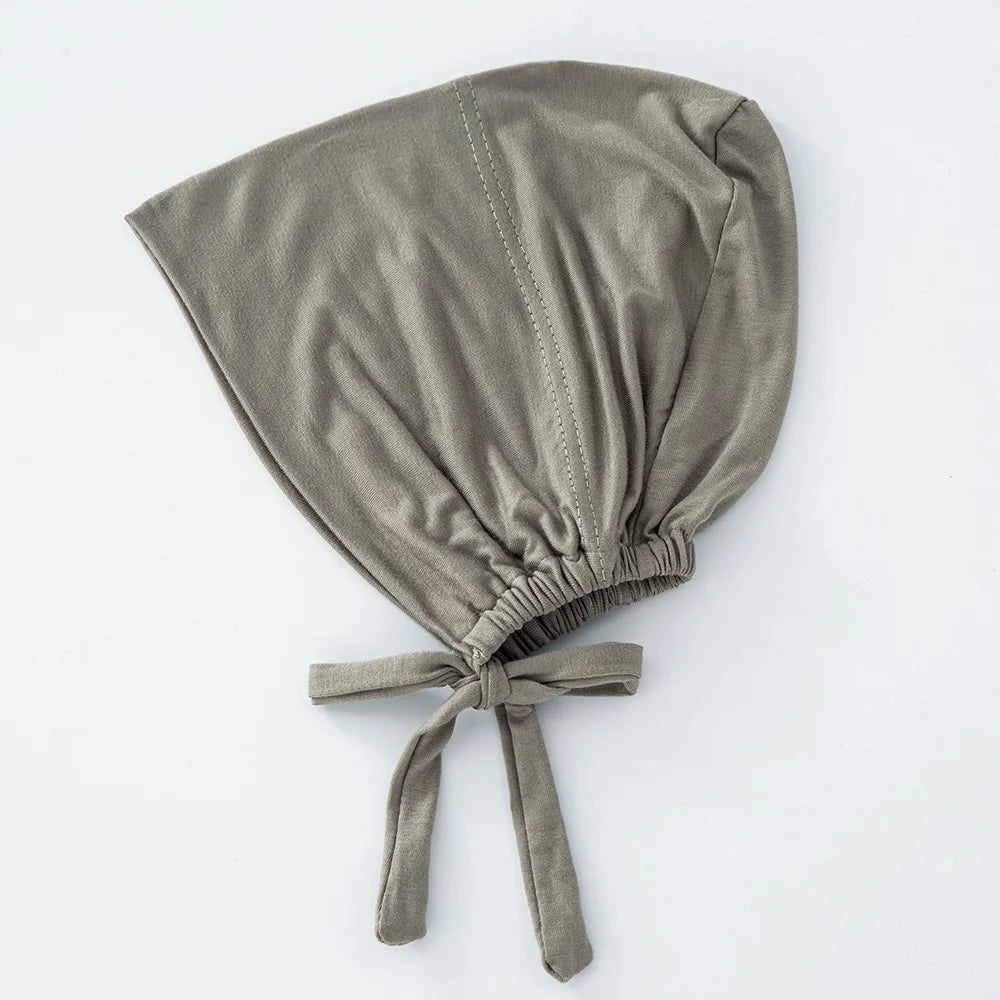 Weicher, gedämpfter olivgrüner Schleier-Inner-Hijab-Bonnet mit zusammengelegtem Stoff und Zopfriemen.