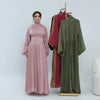Une femme modélise une longue abaya couleur rose poussiéreux avec une ceinture à taille rose et un long manteau assorti.
