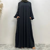 Langes, elegantes schwarzes islamisches Kleid von einem Model vor weißem Hintergrund.