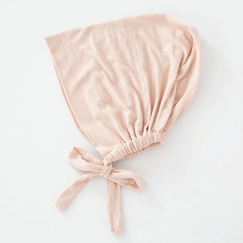 Weiches blassrosa Samt-Tuch mit geraffter Knotenverzierung als Innihجاب-Bonnet.