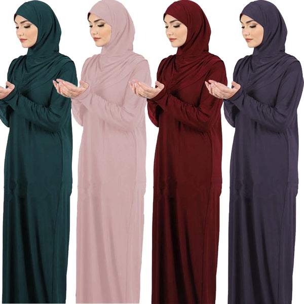 Four women models wearing elegant Islamic abaya kaftans in shades of dark green, pink, maroon, and purple.