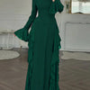 A full-length emerald green maxi dress with a high neckline and ruffled sleeves displayed indoors.