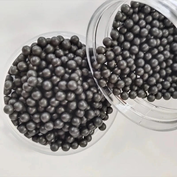 A clear container filled with small, dark gray industrial grade solid rubber sealing balls.