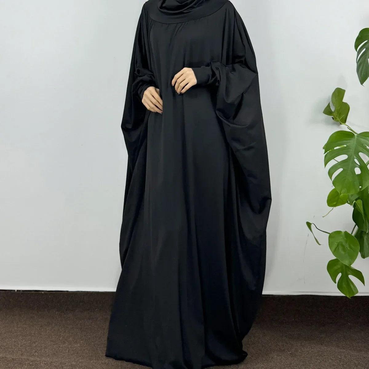 Una mujer vistiendo una elegante abaya negra con capucha para el Ramadán.