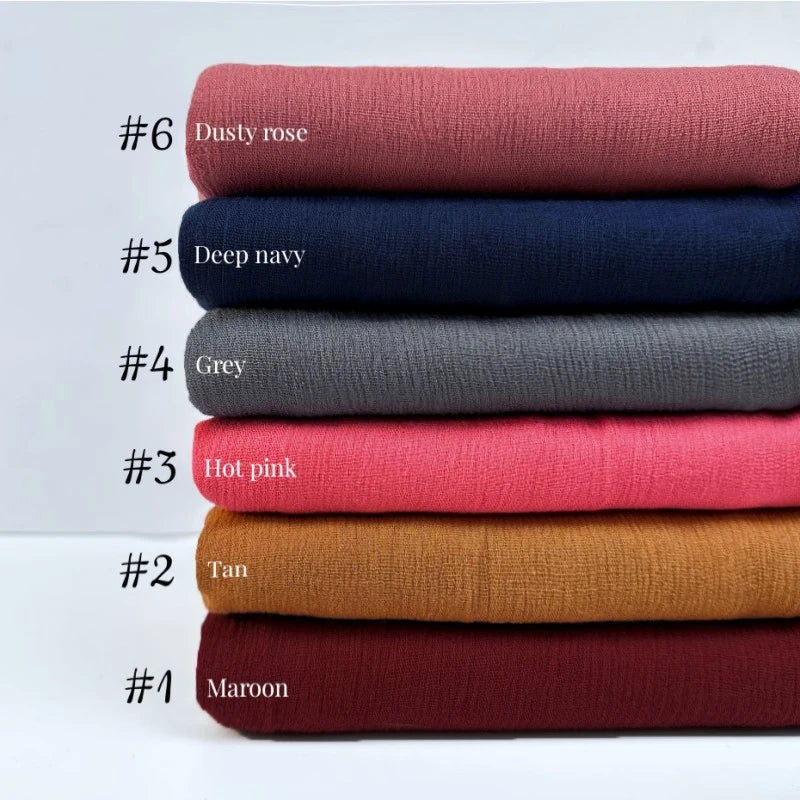 Une pile de neuf rouleaux de tissu colorés, numérotés de #1 à #6, montrant différentes nuances de marron, rose, marine, gris 