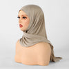 Un modèle porte un foulard triangle beige avec des embellissements argentés.