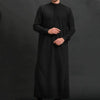 Un hombre vistiendo una jubba thobe casual bordada negra.