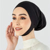 Une femme portant un hijab noir uni et un haut blanc, regardant sur le côté.