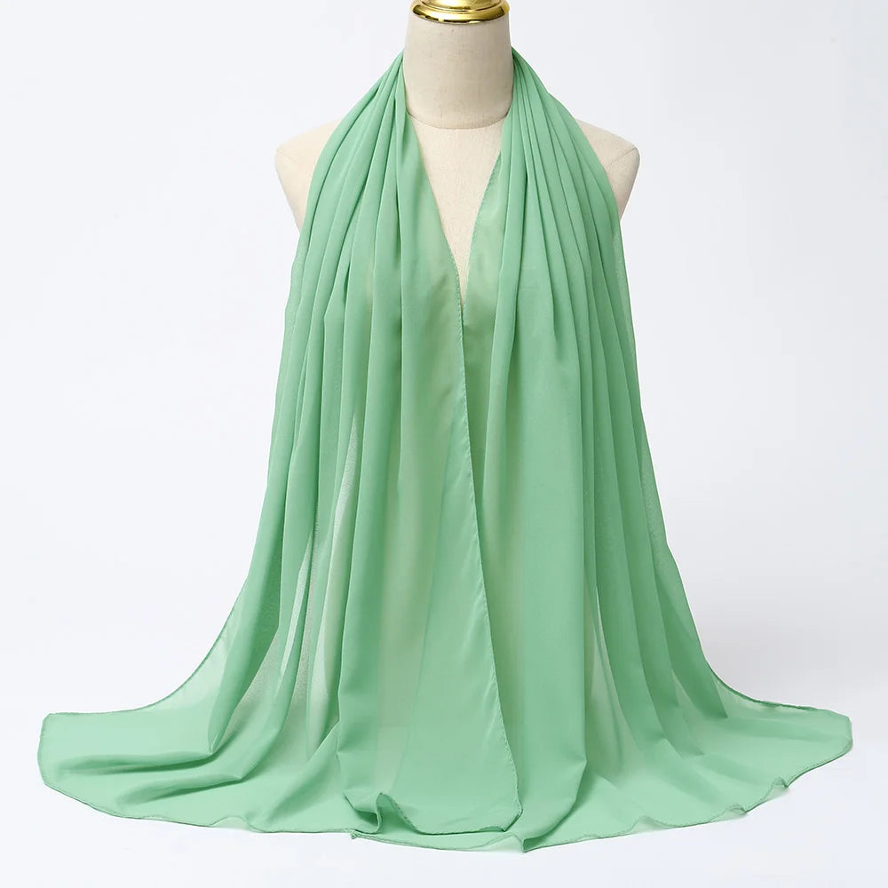 Fließender minigrüner Chiffon-Hijabschal um den Hals eines Mannequins drapiert.