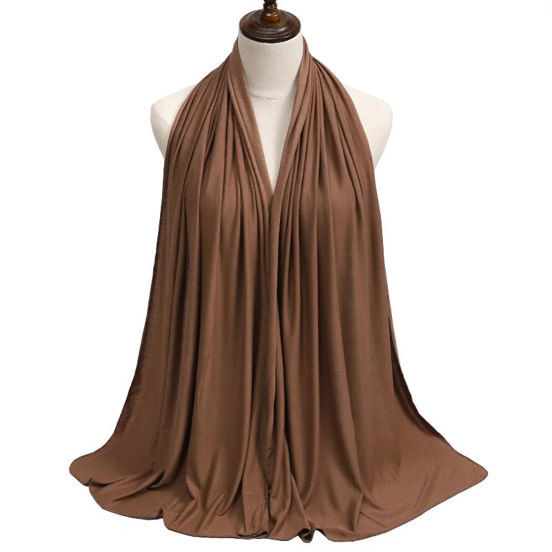 Bufanda pashmina de algodón modal marrón drapeada alrededor del cuello de un maniquí.