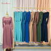 Präsentation fließender, bodenlanger Abayas in verschiedenen Blau-, Türkis- und Olivgrüntönen, aufgehängt in einem goldenen R