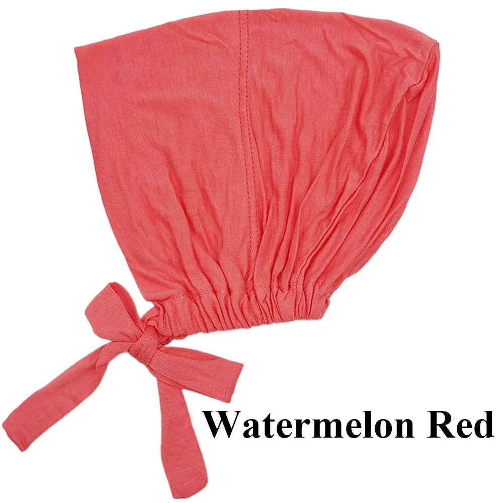 Turban cap made of coral red modal hijab, tied at the bottom.