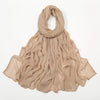 Écharpe/foulard crinkle beige drapé autour du cou et tombant sur les épaules.