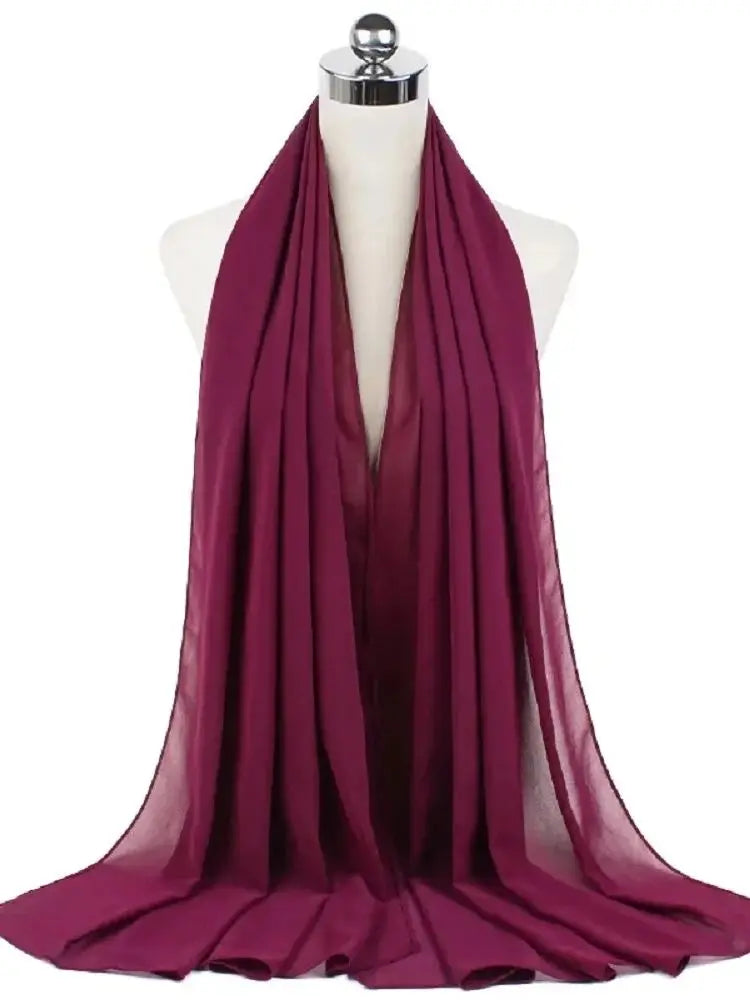 Ein tiefmagenta Chiffon-Hijab-Schal, über den Hals eines Mannequins drapiert.