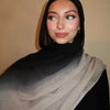 Eine Frau trägt einen Gradient-Rayon-Modal-Hijabschal in Schwarz- und Grautönen.
