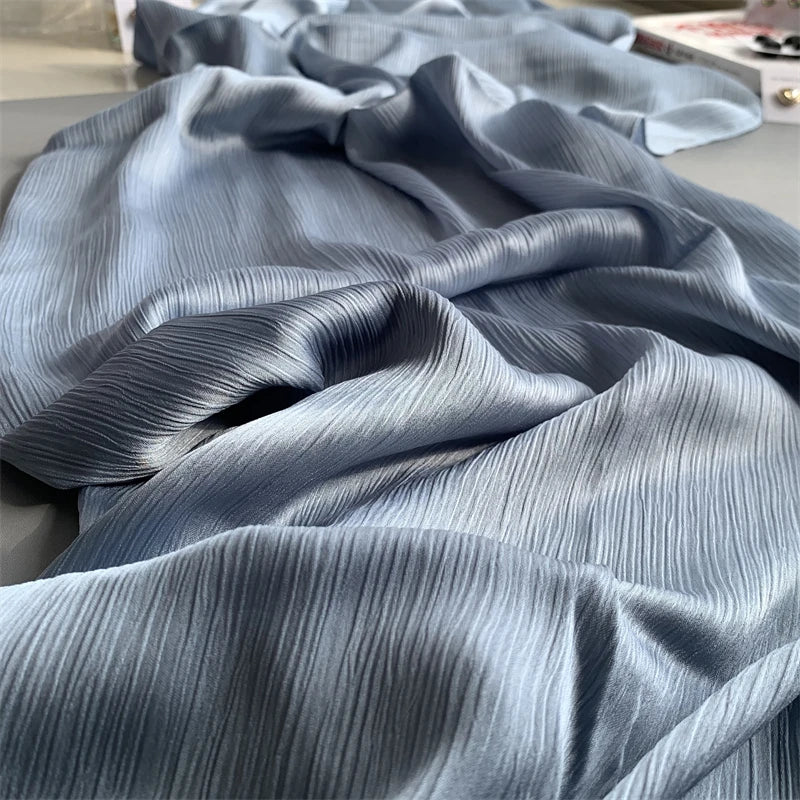 Nahaufnahme eines hellblauen, gerafften Satin-Chiffon-Hijabgewebes, drapiert und gefaltet.