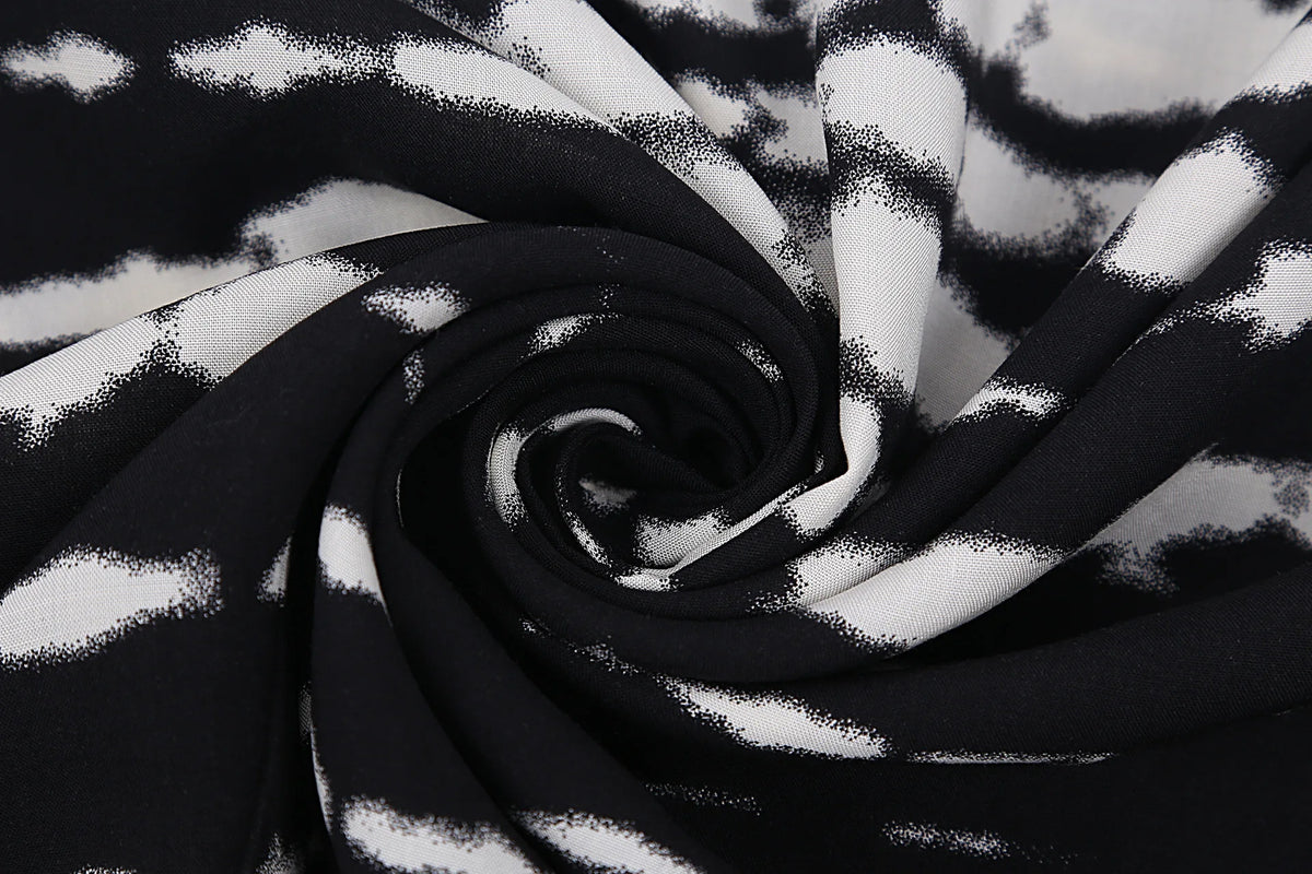 Schwarz-weiß gemusterter Stoff in wirbelndem Fall, als Sommer-Strandkimono-Kleid