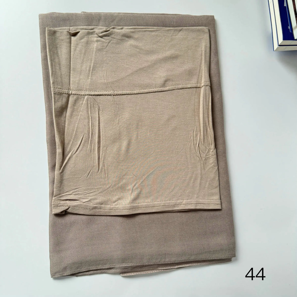 A beige soft modal rayon hijab set folded neatly on a white surface.