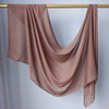 Foulard hijab modal rose poudré, fluide et transparent, drapé sur un cintre en bois.