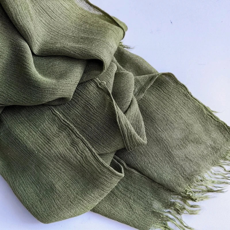 Gros plan d'un foulard hijab en coton viscose vert olive avec des pompons