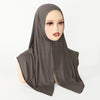 Ein Modell trägt ein einfarbiges braunes Baumwoll-Jersey-Instant-Sport-Hijab, das über Kopf und Hals drapiert ist.