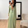 Una mujer modela un abaya de satén verde salvia con corte batwing en un vestido largo en una habitación brillante.