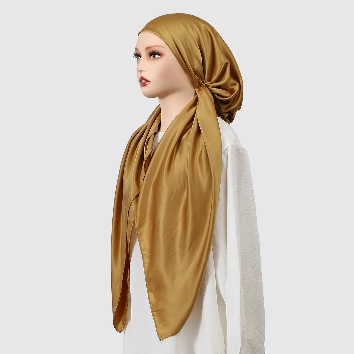 Model trägt einen goldenen Seiden-Instant-Hijabschal um den Hals und den Kopf.