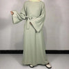 Robe Nida Abaya vert sauge uni avec ceinture, montrée sur mannequin.