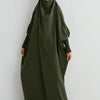 Eine Frau trägt eine olivgrüne, hochgeschlossene Abaya mit gerafften Ärmeln und einem passenden Hijab.