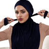Eine Frau trägt einen marineblauen Modal-Jersey-Hijabschal und blickt direkt in die Kamera.