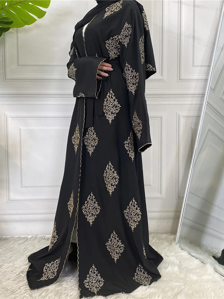 Abaya kaftan islamique noire élégante avec broderie dorée et tissu fluide.