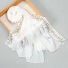 White chiffon hijab shawl with delicate pink floral embroidery displayed on a wooden frame.