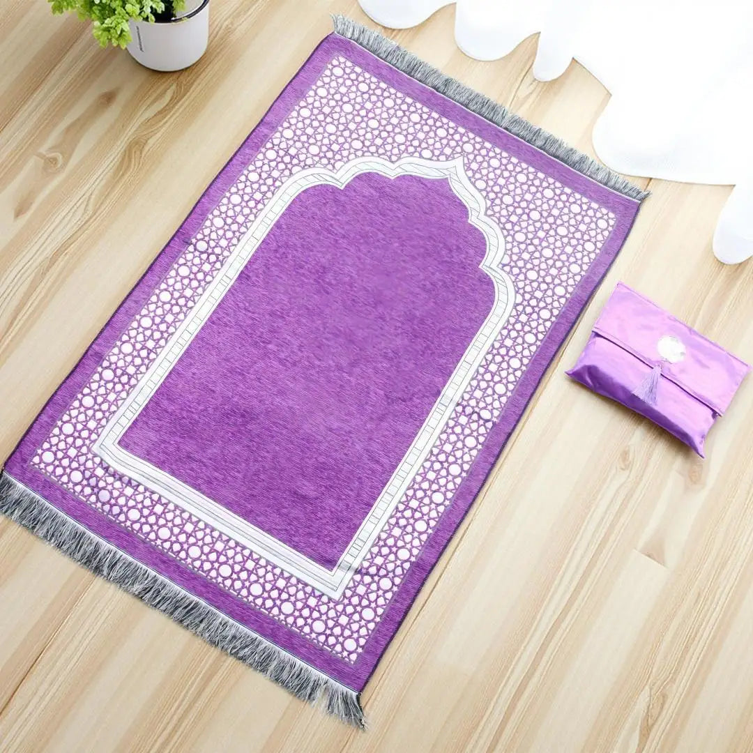 Alfombra de oración musulmana morada con bordado y flecos blancos sobre un suelo de madera.