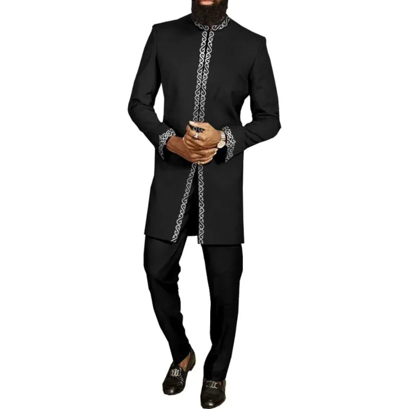 Un homme portant un costume de mariage musulman traditionnel africain noir avec des broderies blanches complexes.