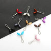 A collection of twelve pearl-colored brooch headscarf pins in various shades and finishes.