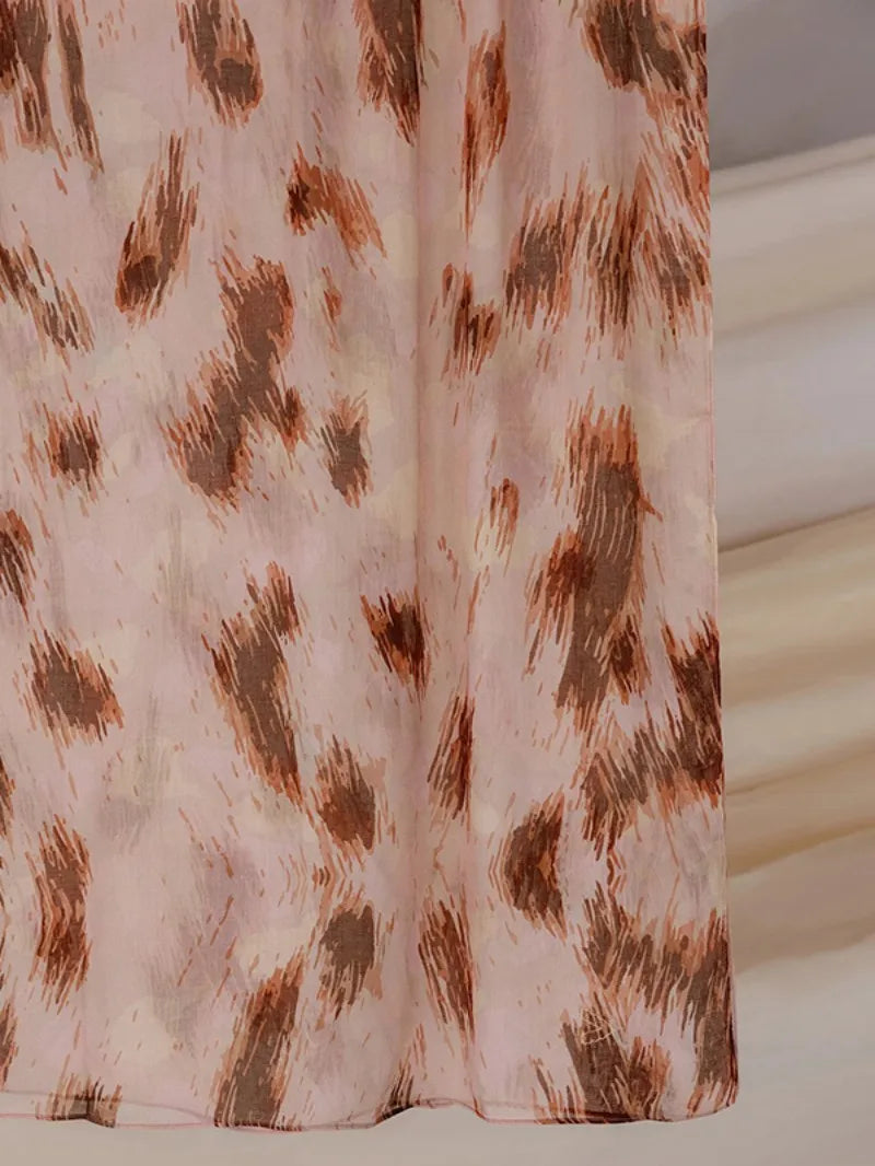 Gros plan d'un foulard hijab en polyester rose pâle avec un motif abstrait d'animal marron.