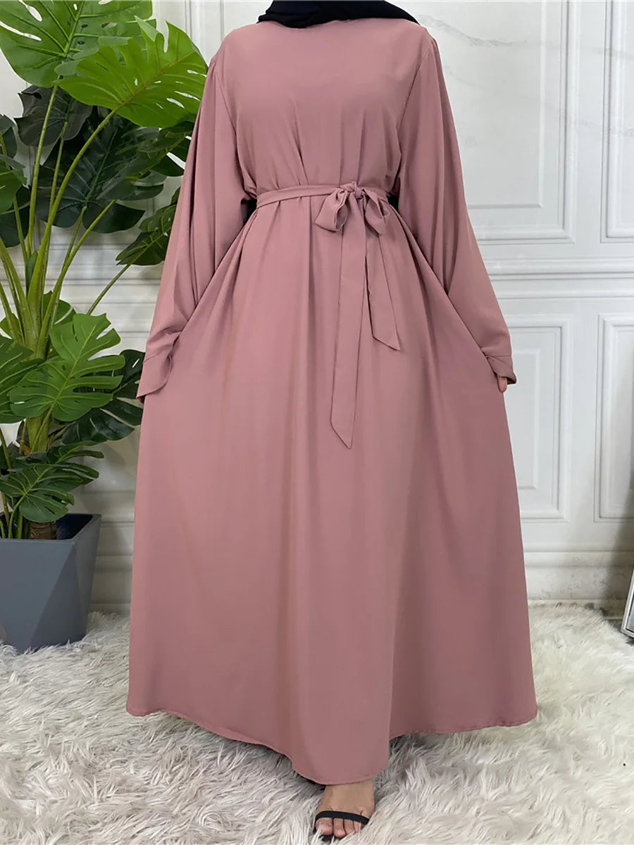 Fließendes, staubrosa Maxi-Abaya für Frauen mit gebundener Taille und langen Ärmeln.