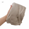 Une main tient un châle/foulard en crêpe beige pour femmes.