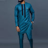 Un homme portant un costume de mariage musulman traditionnel africain bleu sarcelle avec des accents noirs.