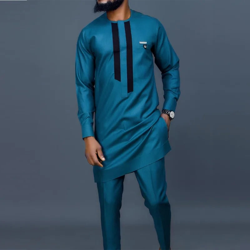 Un homme portant un costume de mariage musulman traditionnel africain bleu sarcelle avec des accents noirs.
