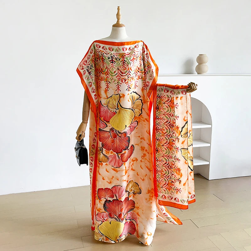 Eine Frau modelliert ein lockeres Sommerkaftan-Kleid mit orange-rosa Blumenmuster und einem Schal.