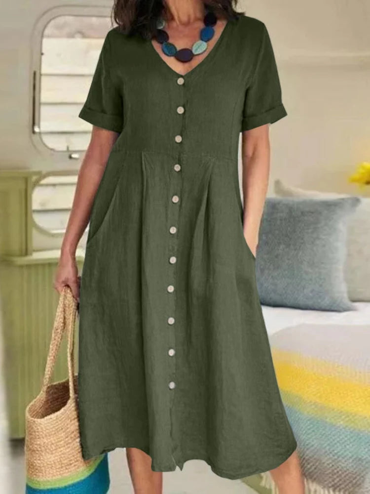 Eine Frau trägt ein olivgrünes Baumwoll- und Hanf-V-Ausschnittkleid im Innenbereich.