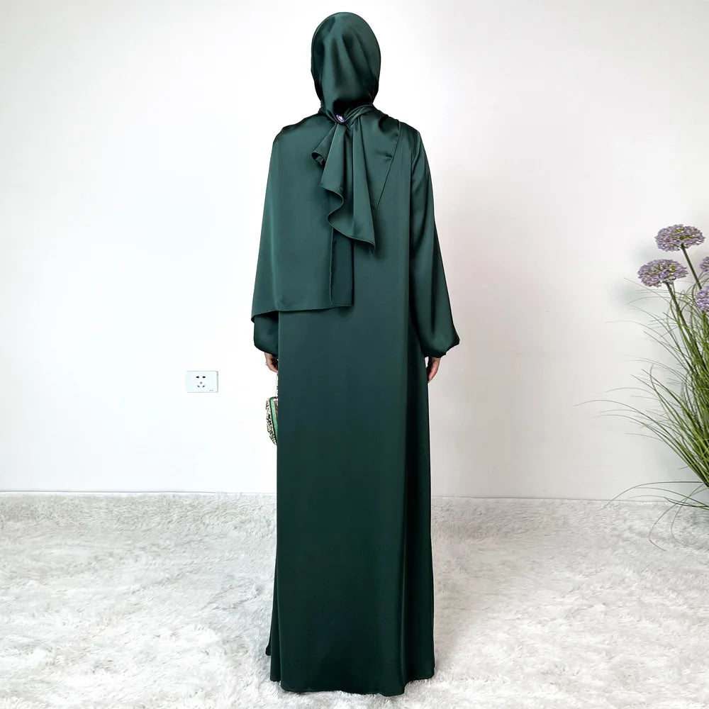 Vestido abaya maxi de satén verde esmeralda oscuro con hijab a juego, sobre fondo blanco.
