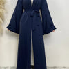 Fließende, dunkelblaue Abaya Kaftan mit offenem Vorderteil für Damen, über einem weißen Top getragen.