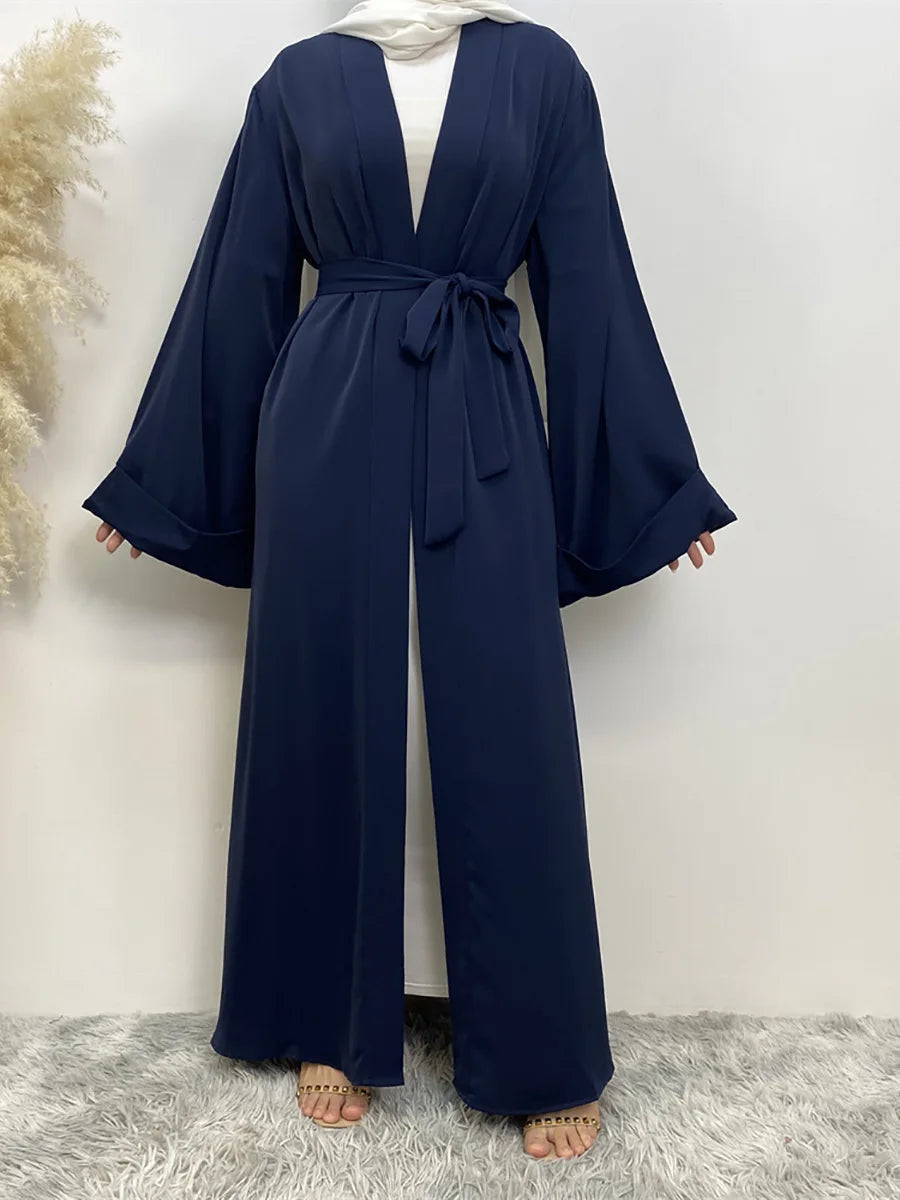 Fließende, dunkelblaue Abaya Kaftan mit offenem Vorderteil für Damen, über einem weißen Top getragen.