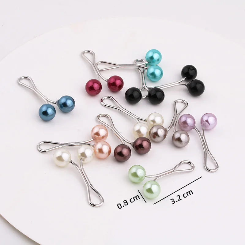 Eine Sammlung von silbernen Perlen-Akzentclips in verschiedenen Farben, darunter blau, pink und schwarz, auf einer weißen Obe